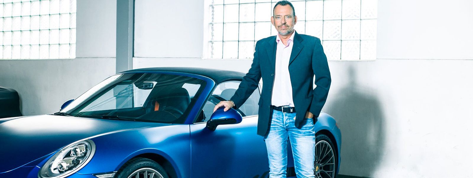 Ralf Matthias Bodenheimer — Geschäftsführer und Ankauf-Experte der Auto-Bodenheimer GmbH, vor einem blauen Porsche 911 Targa